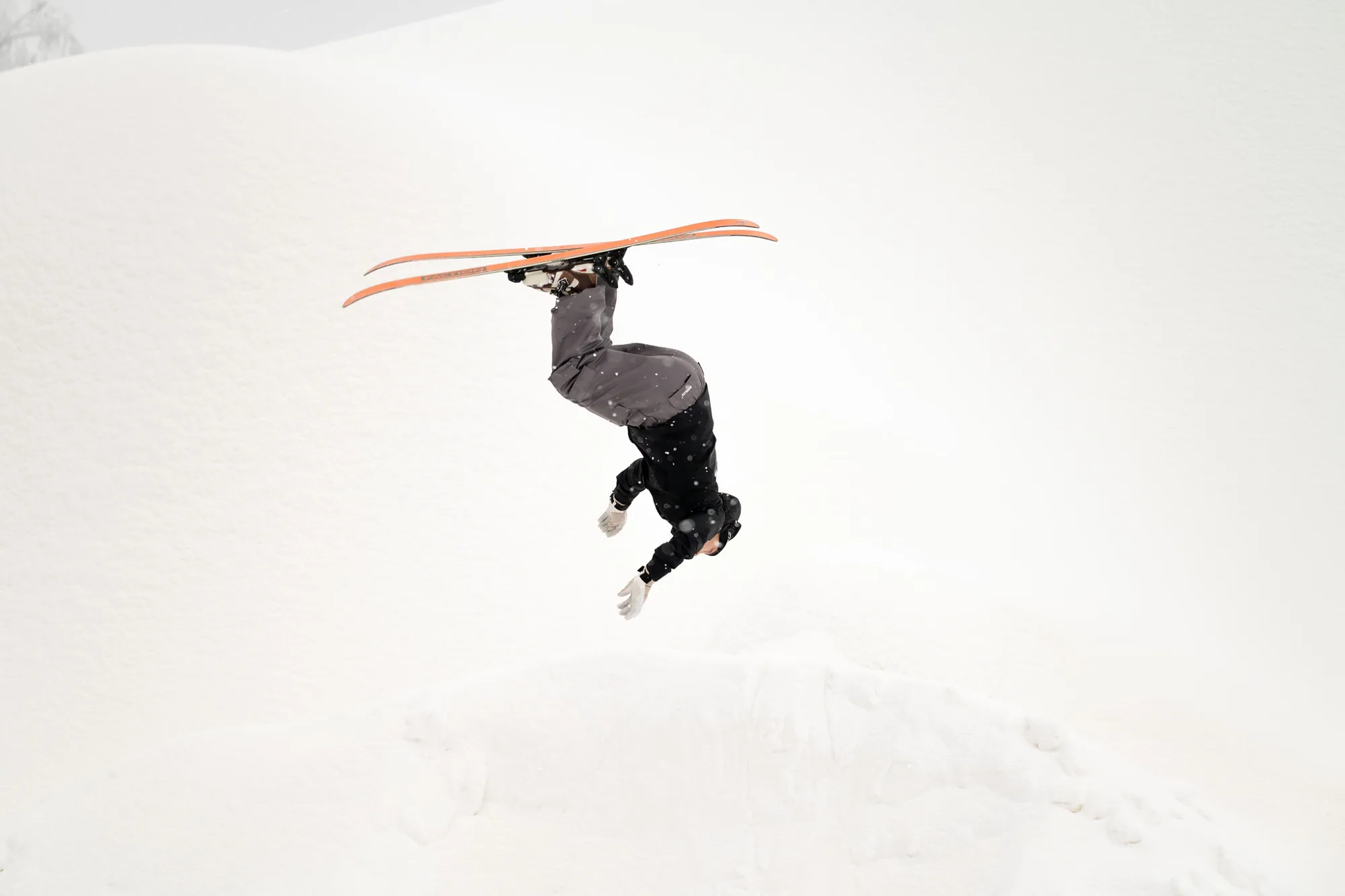 A rider flips over a snow jump at Liugur