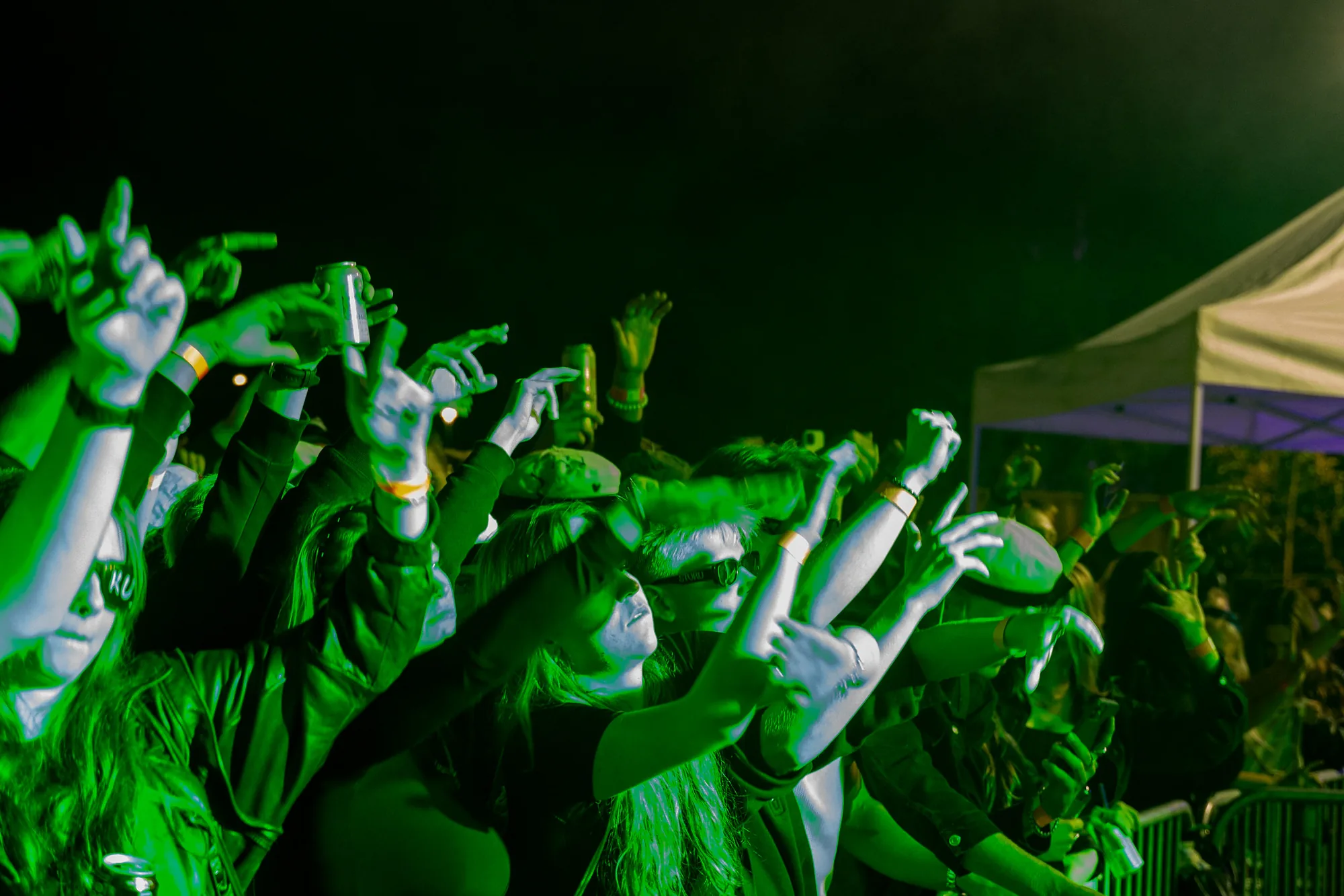 Hands in the air in green light at the Päätösbileet
