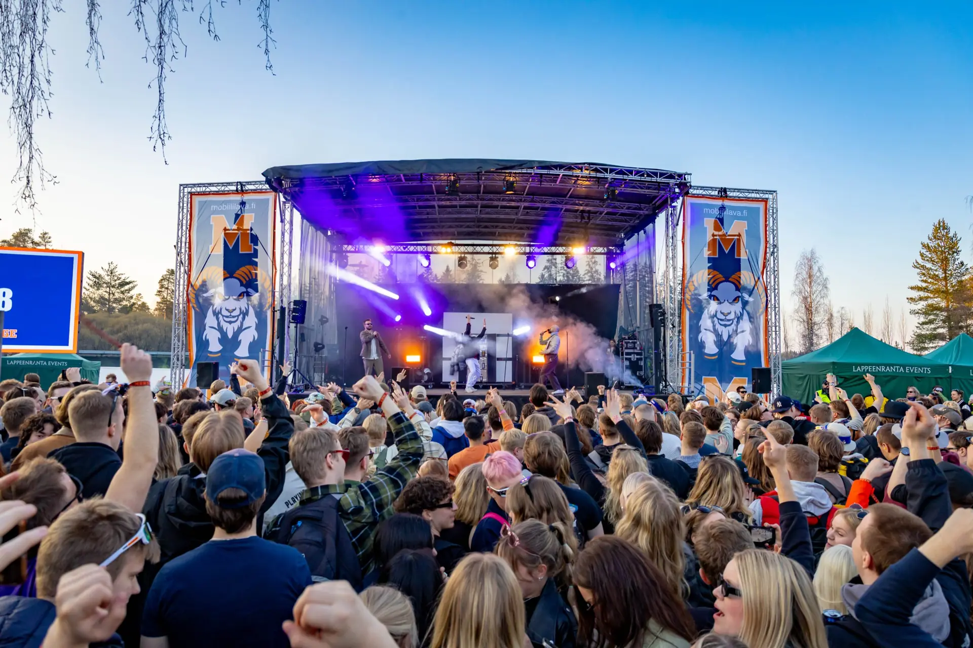 An outdoor stage and crowd at dusk