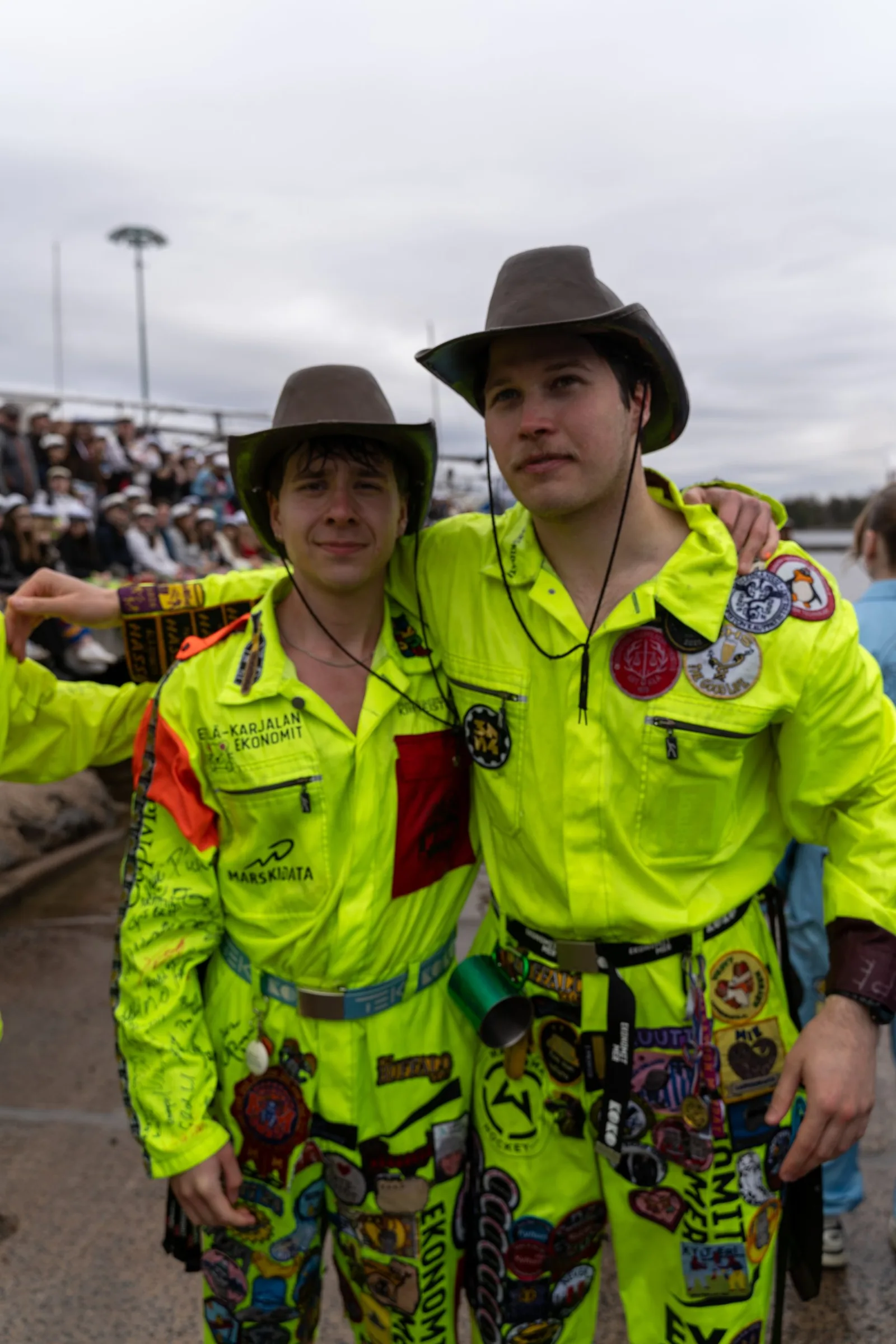 Two Enklaavi members in overalls and hats
